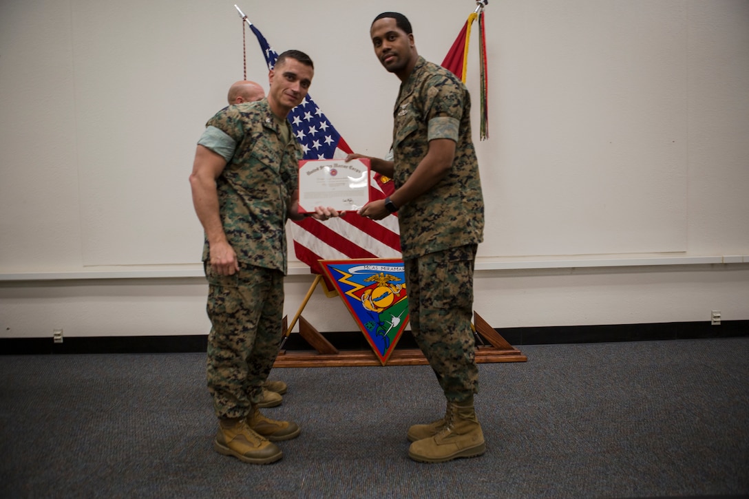 Col. Charles Dockery, commanding officer of Marine Corps Air Station (MCAS) Miramar presents the senior Sailor of the quarter award to LS1 Michael Smith with, Aviation Supply, at MCAS Miramar, Calif., Nov. 1, 2019. The ceremony recognized Marines and Sailors for their exceptional work ethic and achievements during 1st quarter of fiscal year 19. (U.S. Marine Corps photo by Cpl. Preston J. Hightower)