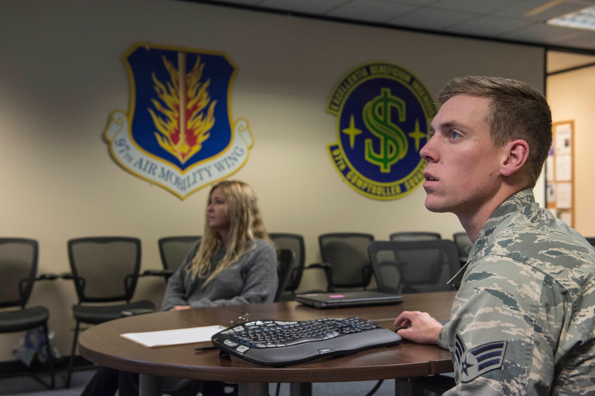 U.S. Air Force Senior Airman Brandon Bray, a financial operations technician assigned to the 97th Comptroller Squadron, helps a user of the Defense Travel System with an issue