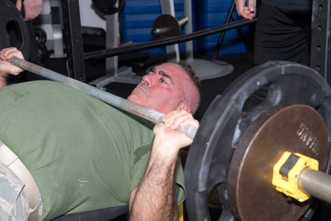 Master Sgt. Robert Guyer, the non-commissioned officer in charge of the 157th Maintenance Group, benches more than 100 pounds during the first weight lifting competition held at Pease Air National Guard Base, N.H. Nov. 4, 2018. The competition included squat, deadlift, bench and run components. (Photo by Airman 1st Class Victoria Nelson, 157th ARW Public Affairs)