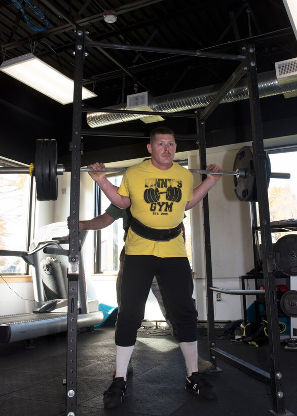 Tech Sgt. Daniel Mooers, a power production operator with the 157th Air Refueling Wing squats 300 pounds during the first weight lifting competition held at Pease Air National Guard Base, N.H. Nov. 4, 2018. The competition was part of the Aircraft Maintenance Squadron's commander's challenge and included squat, deadlift, bench and run components. (Photo by Airman 1st Class Victoria Nelson, 157th ARW Public Affairs)