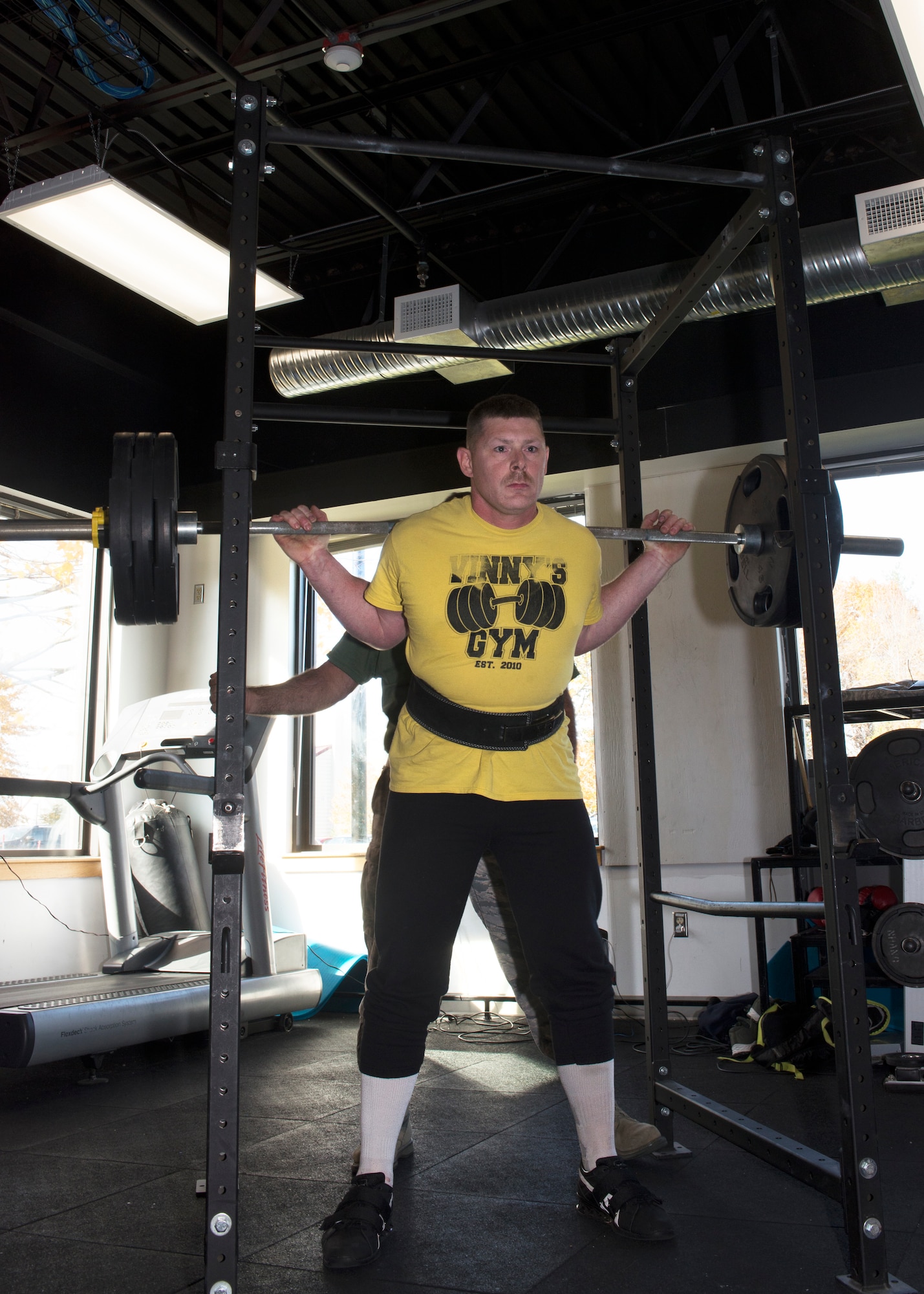 Tech Sgt. Daniel Mooers, a power production operator with the 157th Air Refueling Wing squats 300 pounds during the first weight lifting competition held at Pease Air National Guard Base, N.H. Nov. 4, 2018. The competition was part of the Aircraft Maintenance Squadron's commander's challenge and included squat, deadlift, bench and run components. (Photo by Airman 1st Class Victoria Nelson, 157th ARW Public Affairs)