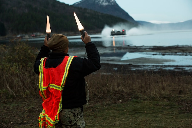 A beach master directs a landing craft air cushion during an amphibious landing in support of Trident Juncture 18 on Alvund Beach, Norway, Oct. 30, 2018.