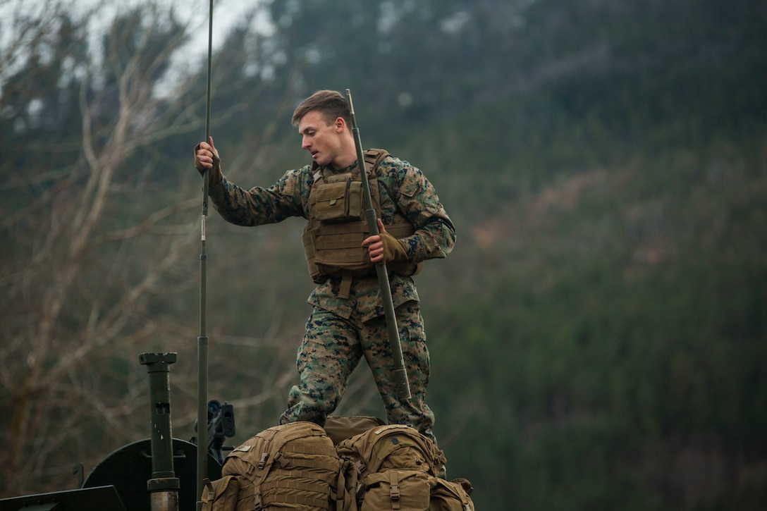 A Marine adjusts equipment on a light armored vehicle on Alvund Beach, Norway during an amphibious landing in support of Trident Juncture 18, Oct. 30, 2018. Trident Juncture provides a unique environment for the Marines and Sailors to rehearse their amphibious capabilities. The LAVs originated from USS New York (LPD 21) and showcased the ability of the Iwo Jima Amphibious Ready Group and the 24th Marine Expeditionary Unit to rapidly project combat power ashore. The Marine is with 2nd Light Armored Reconnaissance Battalion, 24th MEU. (U.S. Marine Corps photo by Lance Cpl. Margaret Gale)