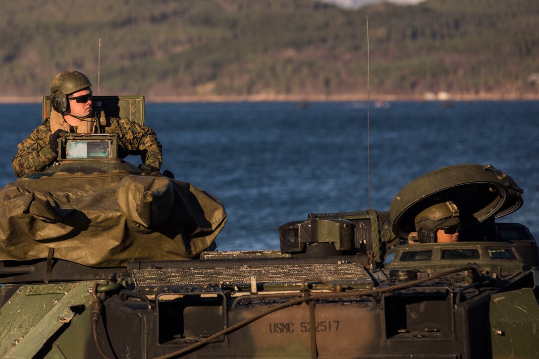 Marines prepare equipment on a light armored vehicle at Alvund Beach, Norway during an amphibious landing in support of Trident Juncture 18, Oct. 30, 2018. Trident Juncture provides a unique environment for the Marines and Sailors to rehearse their amphibious capabilities. The LAVs originated from USS New York (LPD 21) and showcased the ability of the Iwo Jima Amphibious Ready Group and the 24th Marine Expeditionary Unit to rapidly project combat power ashore. The Marines are with 2nd Light Armored Reconnaissance Battalion, 24th MEU. (U.S. Marine Corps photo by Lance Cpl. Margaret Gale)