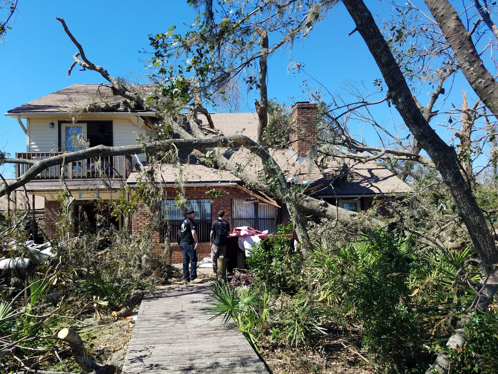 Airmen from the 2nd Combat Weather Systems Squadron inspect the damage of a fellow Airman’s family home in Panama City, Florida, Oct. 13, 2018. Airmen and their spouses took a moving van to recover furniture and family heirlooms before mold damage could set in. (Courtesy Photo)