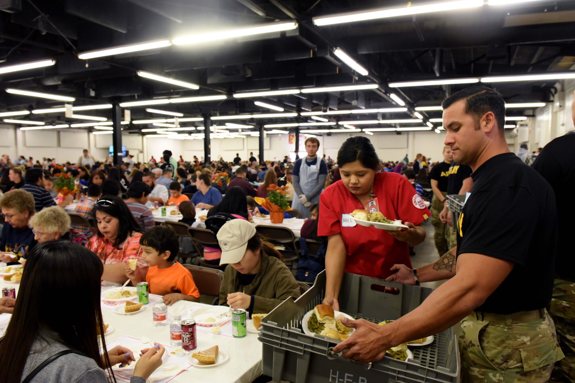 Sgt. 1st Class Jonathon Murphy, 344th Military Intelligence Battalion instructor, delivers food during the Feast of Sharing at the Wells Fargo Pavilion in San Angelo, Texas, Nov. 4, 2018. The Feast of Sharing is an event that provides a Thanksgiving meal, music and kid-friendly activities to families in Texas. (U.S. Air Force photo by Senior Airman Randall Moose/Released)