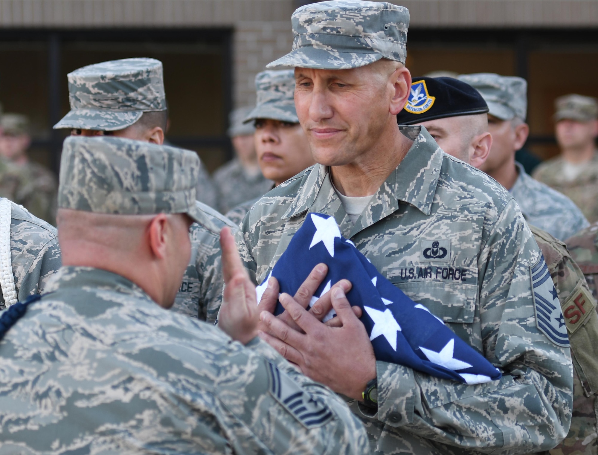 U.S. Air Force Senior Master Sgt. Andrew Bodine, 81st Training Group military training superintendent, presents Chief Master Sgt. Kenneth Carter, 81st Training Wing command chief, with the U.S. Flag during a retreat ceremony at Keesler Air Force Base, Mississippi, Nov. 2, 2018. The ceremony was held in honor of Carter who retired with more than 29 years of military service. (U.S. Air Force photo by Kemberly Groue)