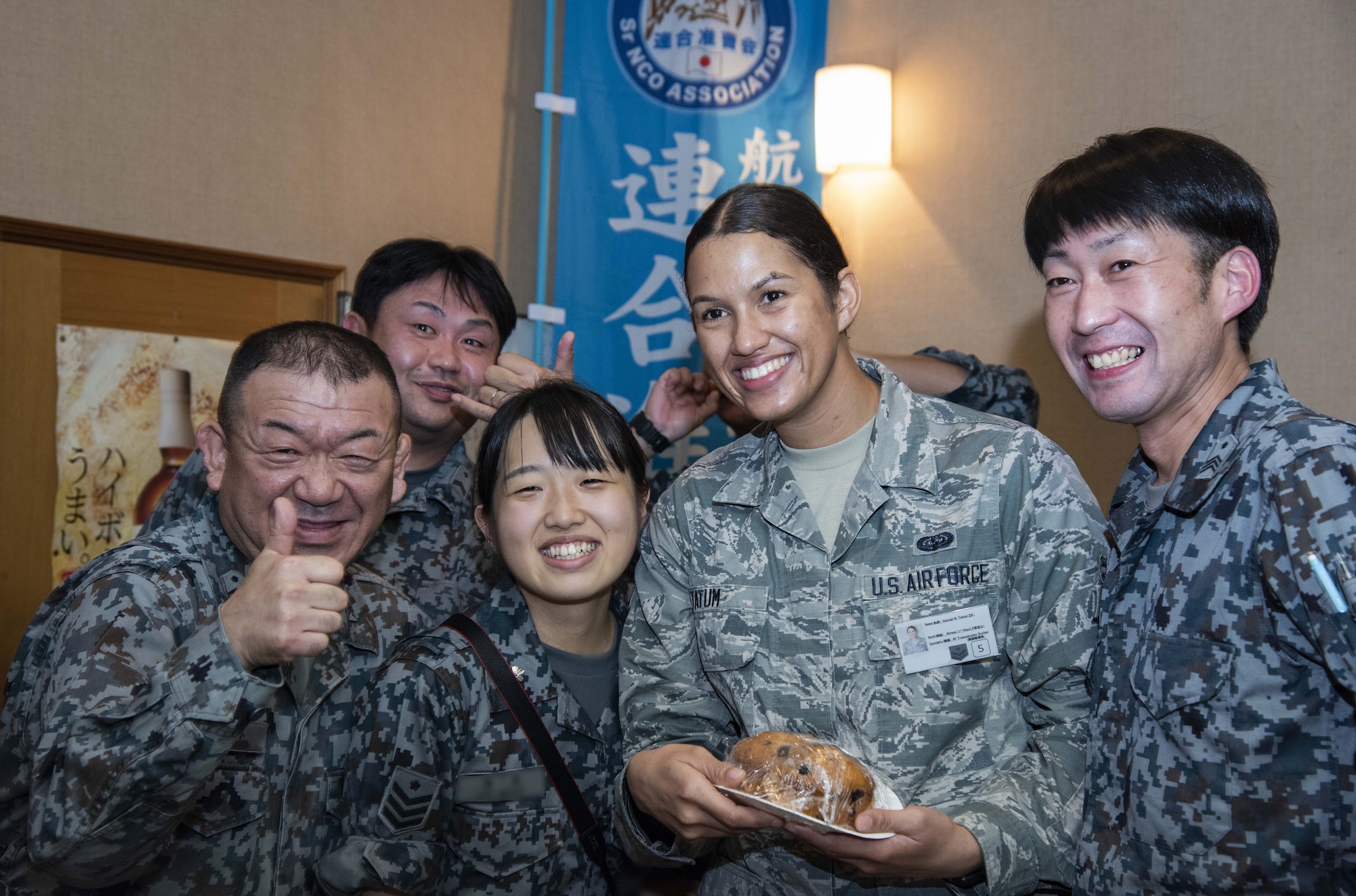 Japan Air Self-Defense Force members with the 37th Surveillance Squadron and a U.S. Air Force Airman 1st Class Hannah Tatum, a 35th Communications Squadron radio frequency transmissions systems technician, pause for a photo during a bilateral exchange program at Yamada Sub Base, Yamada Town, Japan, Oct. 17, 2018. During the exchange, personnel worked together and fellowshipped with one another to deepen bonds and better enhance mission execution through getting to know each other in and out of a work environment. (U.S. Air Force photo by Senior Airman Sadie Colbert)