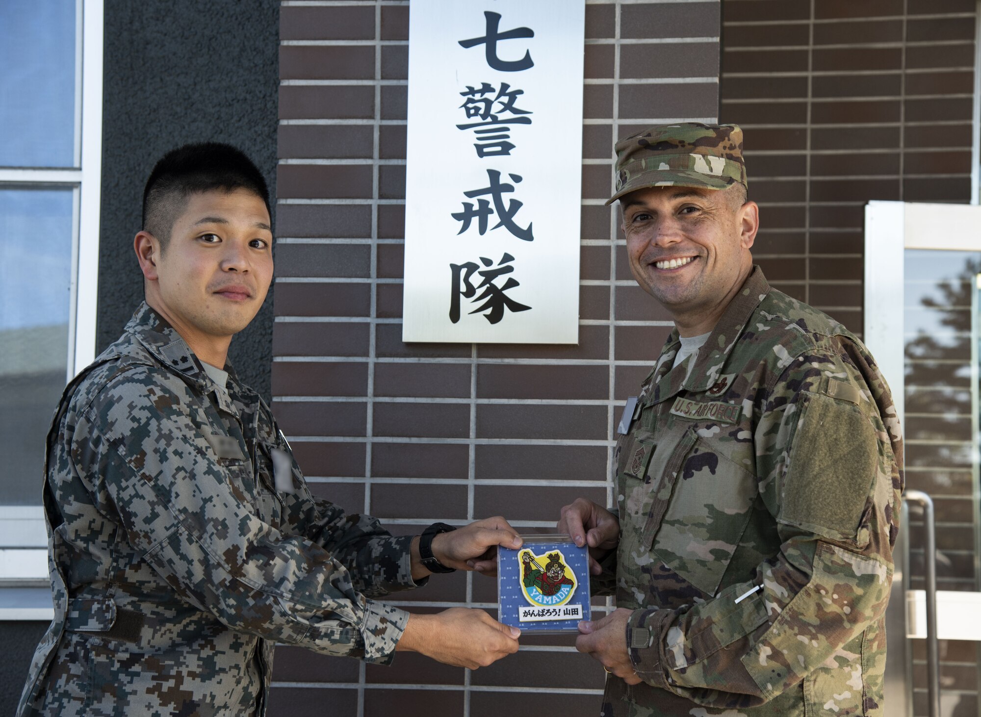 Japan Air Self-Defense Force 1st Lt. Kimamura, left, a 37th Surveillance Squadron weapons director, gives U.S. Air Force Chief Master Sgt. John Alsvig, right, the 35th Fighter Wing command chief, a gift during a bilateral exchange program at Yamada Sub Base, Yamada Town, Japan, Oct. 18, 2018. Alsvig stayed for the first two days of the exchange to learn about the 37th Surveillance Squadron’s mission and how they work alongside their allies to maintain peace and balance in the Indo-Pacific region. (U.S. Air Force photo by Senior Airman Sadie Colbert)