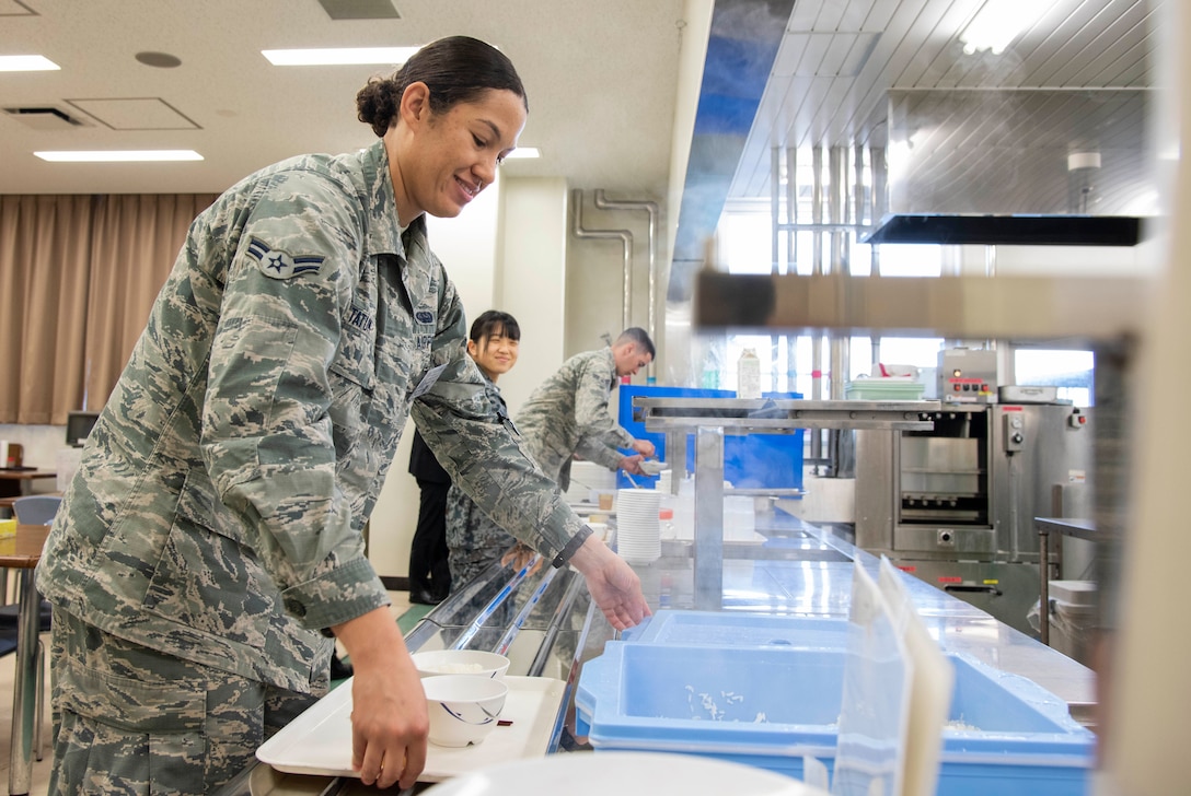 U.S. Air Force Airman 1st Class Hannah Tatum, a 35th Communications Squadron radio frequency transmission systems technician, grabs rice during a bilateral exchange program at Yamada Sub Base, Yamada Town, Japan, Oct. 18, 2018. During the event, U.S. Air Force service members stayed with Japan Air Self-Defense Force counterparts, learning to better integrate with each other and reinforce U.S. and Japan relations. (U.S. Air Force photo by Senior Airman Sadie Colbert)
