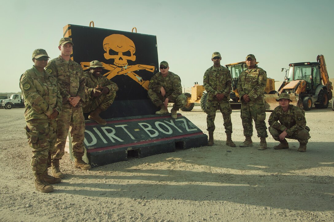 U.S. Air Force Airmen from the 379th Expeditionary Civil Engineer Squadron pavements and equipment shop, stand next to their unit mural Nov. 5, 2018, at Al Udeid Air Base, Qatar. Airmen from the flight conducted quick-turn repairs to the base flight line after it was damaged by a lightning storm Oct. 24. (U.S. Air Force photo by Tech. Sgt. Christopher Hubenthal)