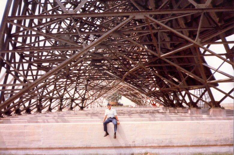 Incirlik Air Base Historical photo of an Airman posing under a metal superstructure on the base flight line.