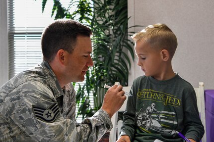 Staff Sgt. Robert Youmans, 628th Aerospace Medical Squadron NCO in charge of community health, gives a fake vaccination to a youth center member during a mock pre-deployment, Nov. 3, 2018, at Joint Base Charleston, S.C.