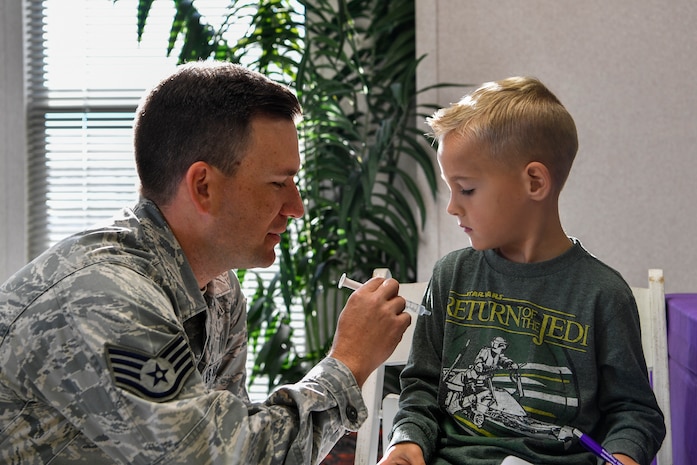 Staff Sgt. Robert Youmans, 628th Aerospace Medical Squadron NCO in charge of community health, gives a fake vaccination to a youth center member during a mock pre-deployment, Nov. 3, 2018, at Joint Base Charleston, S.C.