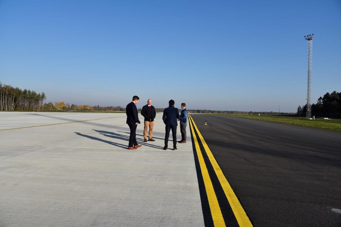 Four men stand on a hot cargo pad.