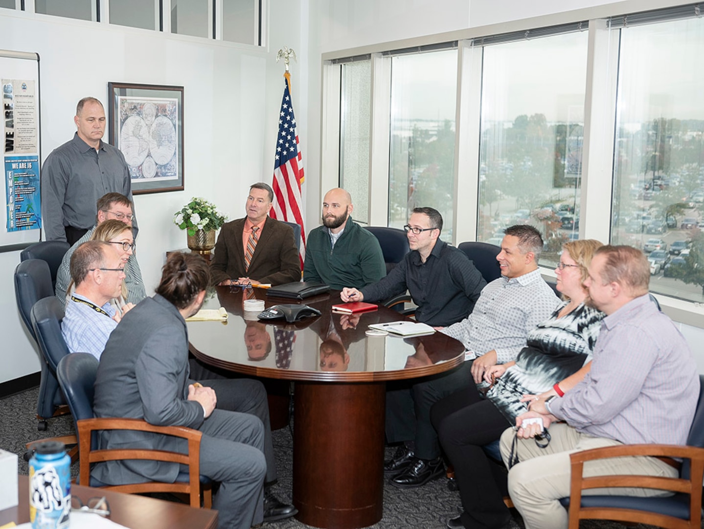 Eleven representatives sit around a table for a Technology Council meeting