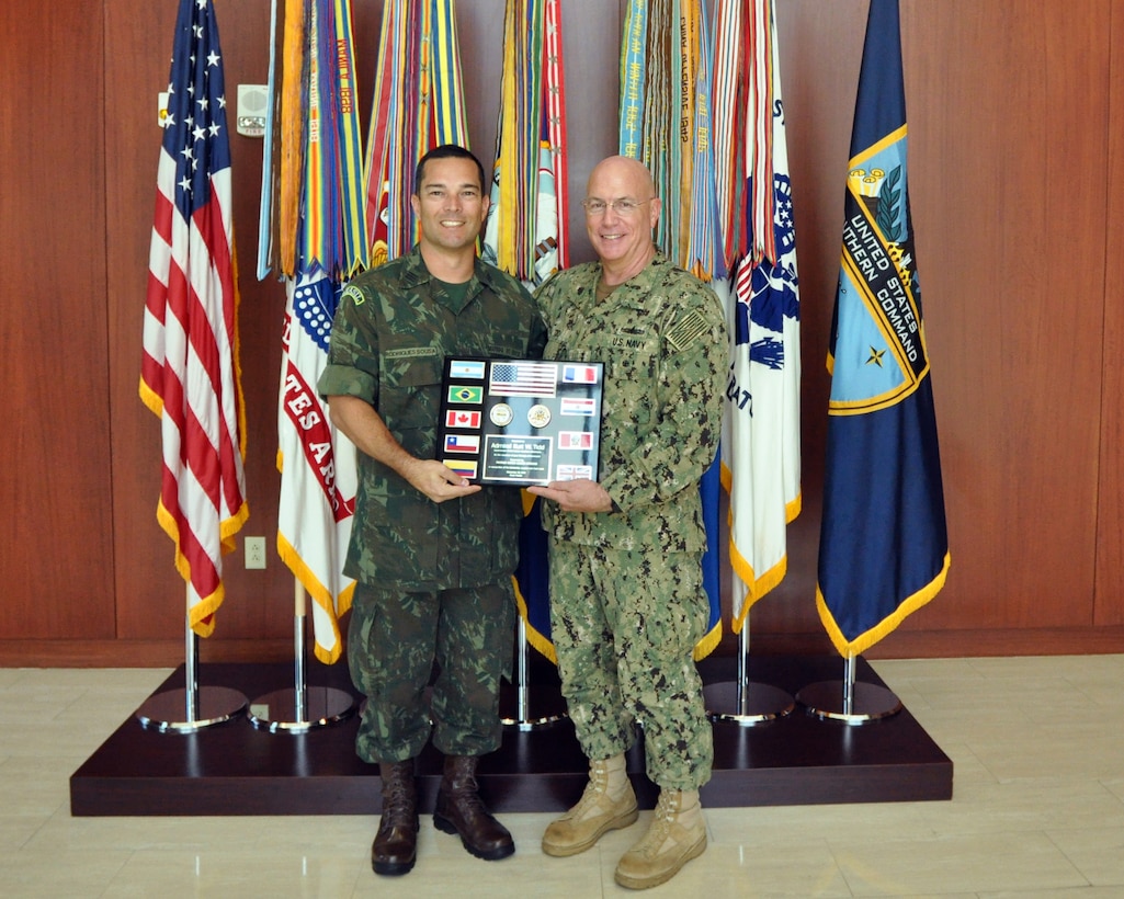 Brazilian Navy Cdr. Domingos Rodriguez Sousa, Partner Nation Liaison Officer (PNLO) assigned to U.S. Southern Command (SOUTHCOM) presents a plaque of appreciation to Adm. Kurt Tidd.