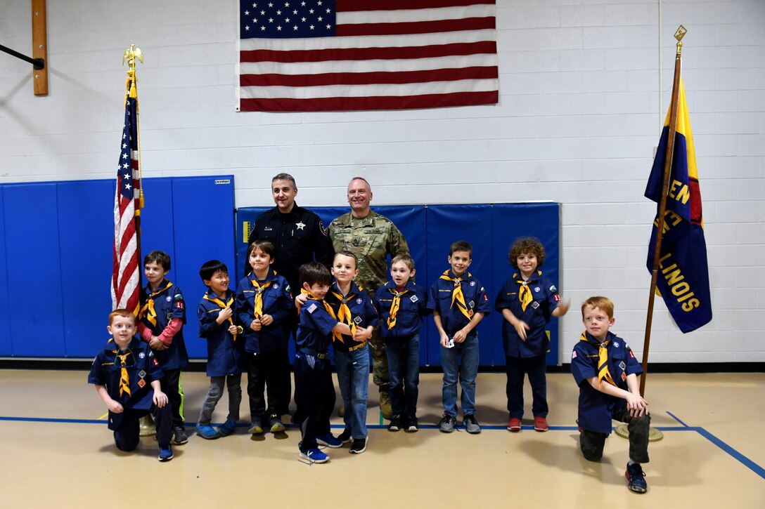 Sgt. David Lietz, public affairs sergeant with the 85th Support Command, pauses for a photo with Officer Joel Detloff, from the Glenview Police Department and students from Lyon Elementary School during the school’s Veteran’s Day observance in Glenview, Illinois, November 5, 2018.