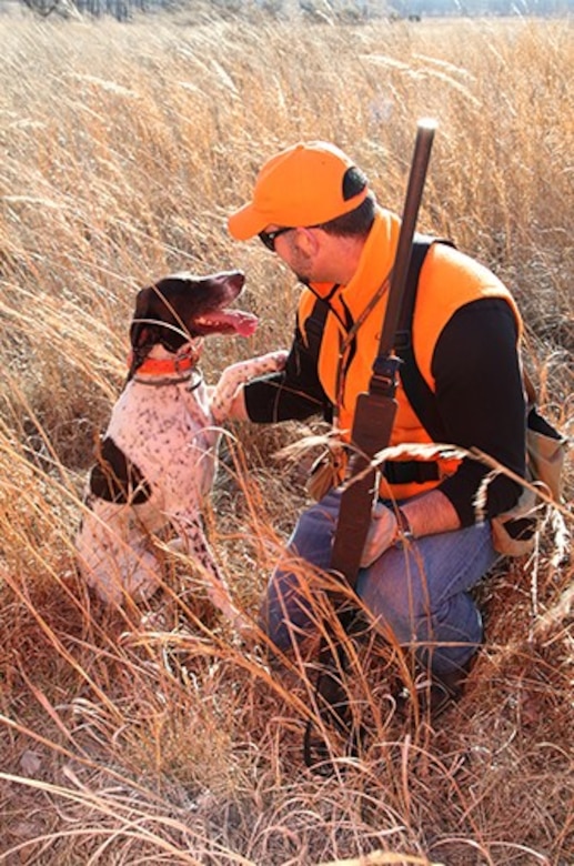 The Kansas City District urges all hunters to wear proper attire and be very conscious of their surroundings. Here a hunter works with a hunting dog.