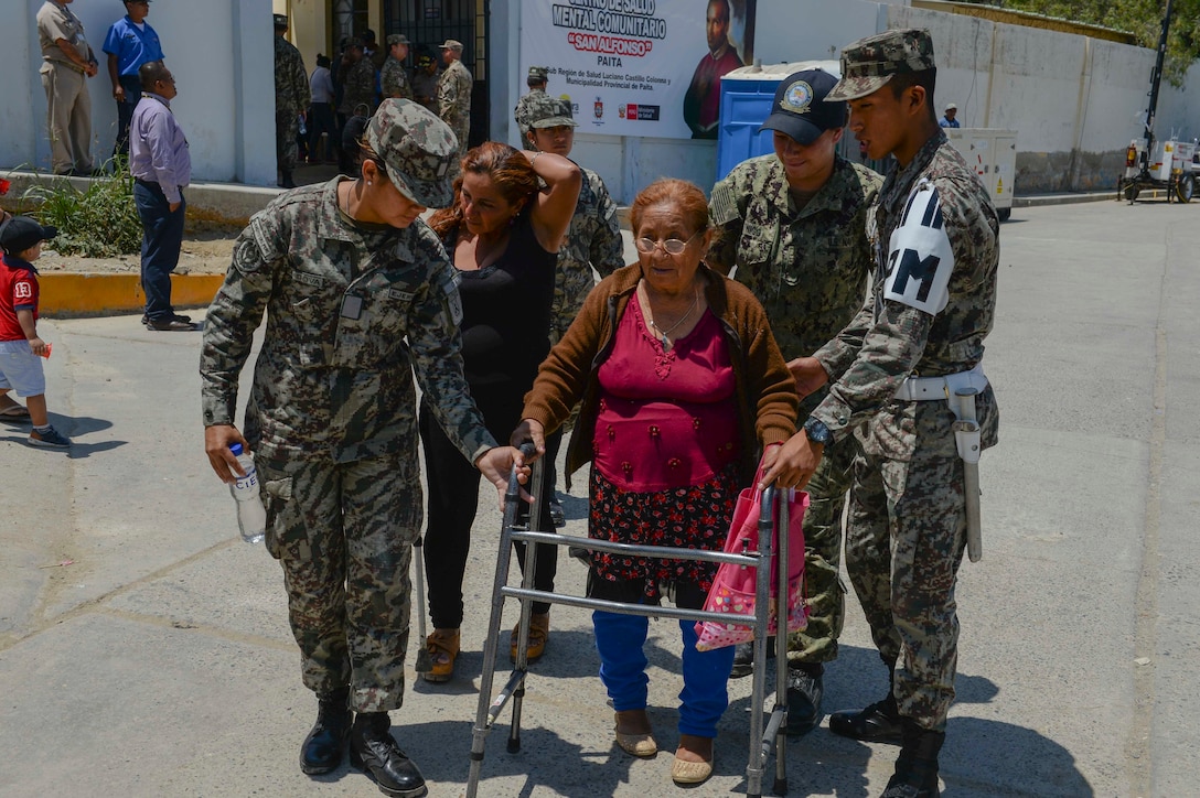 Hospitalman Apprentice Amber-Lynn Twigg (center-right), from Las Vegas, and Peruvian forces assist a patient outside one of two medical sites.