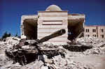 Two destroyed tanks in front of a mosque in Azaz, Syria. A battle between the Free Syrian Army (FSA) and the Syrian Arab Army (SAA) was fought from March to July in 2012 for control over the city of Azaz, north of Aleppo, during the Syrian civil war. (Christian Triebert) https://www.flickr.com/photos/christiaantriebert/7955551210/in/photolist-d81hd3-hHUUvN-hHTXzB-fatNA7-fk4mmb-fjPaNt-fk4nUL-fk4zjQ-fk4w7Y-fk4vD7-rjjjt6-fk4rvq-fk4wSo-fjPdRp-fjPm6H-pPYm2H-fk4pvu-AKQ15P-DNX2At-AJCGN9-DNX2mk-t411ip-xDKhtL-xF6mL8-xCa2E7-xnRYk3-xDD42j-xC9XqW-wHASdz-wHAHBr-xnRWxL-xnYrd8-xF5R6X-xnXTB2-xDCSH3-xF6kD8-xC9sAb-xnY4jZ-xF6gT2-xEt2cp-xnXYwc-xDCDdC-xnRJ9Y-xnXWQ6-xEtsmH-wHAt9D-xEtvnc-xDD2jS-xDD88f-xF69Xt/. Licensed under Creative Commons Attribution 2.0 Generic License. Photo unaltered.