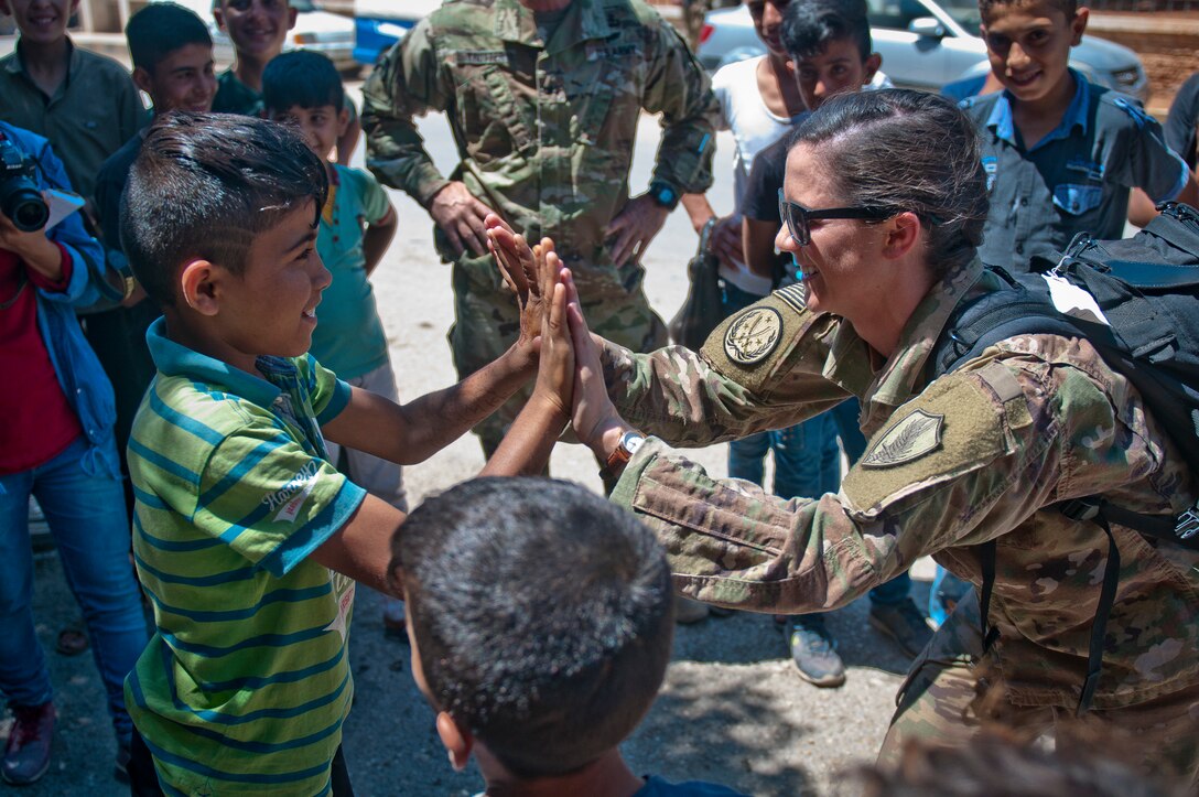 Coalition advisor plays game with child during tour of Manbij, Syria, June 21, 2018, to document how safe and prosperous it has become since Syrian
Democratic Forces defeated so-called Islamic State (U.S. Army/Timothy R. Koster)