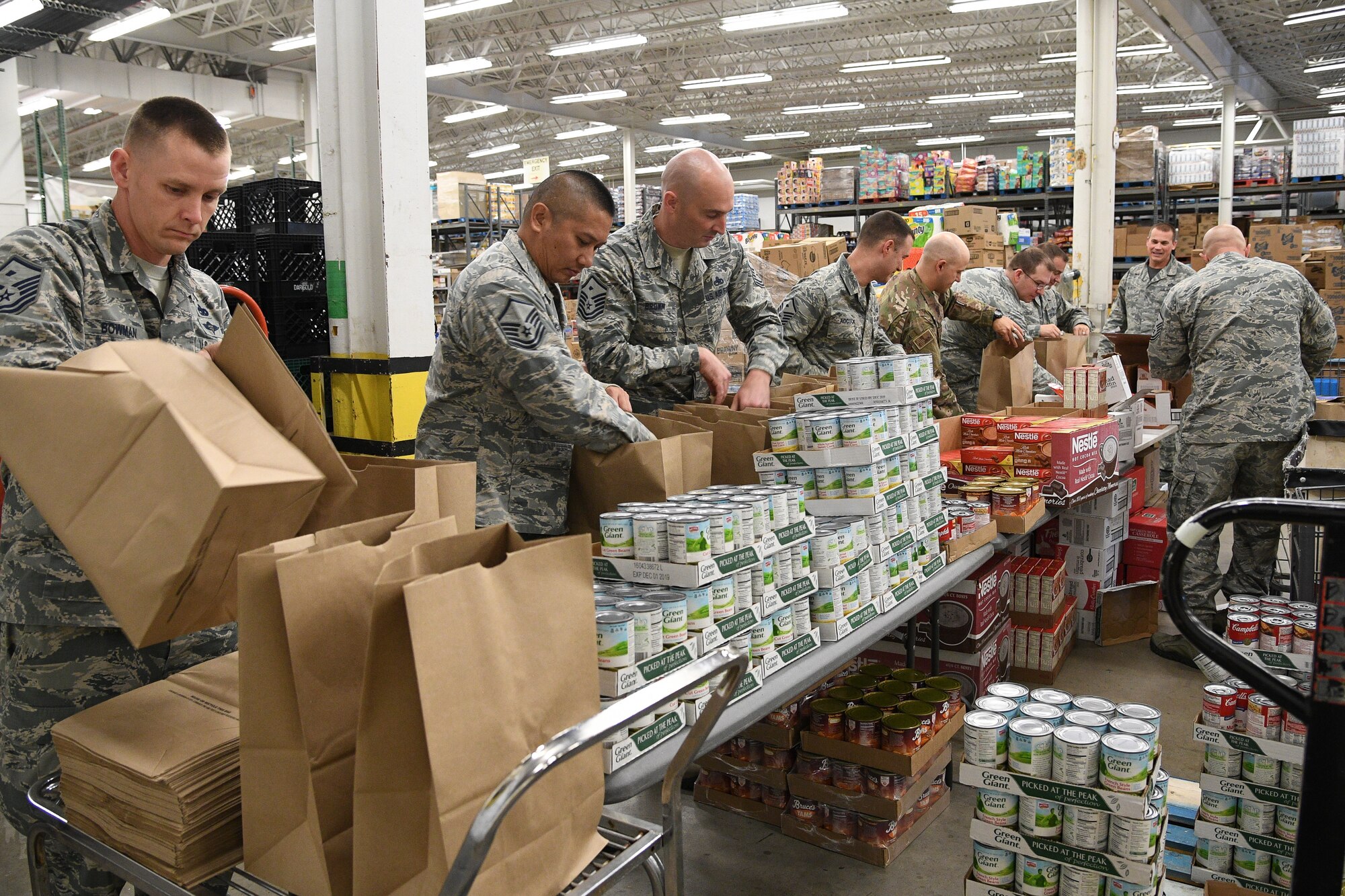 Members of Hill's First Sergeant Council pack Operation Warm Heart Thanksgiving bags on Nov. 2 at Hill Air Force Base, Utah. The bags of sides dishes along with a turkey and a pie donated by commissary vendors will be delivered to selected Airmen to assist with the upcoming holiday. (U.S. Air Force photo by R. Nial Bradshaw)