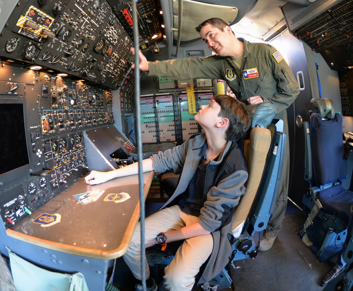Lt. Col. Ryan A. Clark, 356th Airlift Squadron flight instructor, explains functions of the flight engineer station to Kenneth Dilanian III Nov. 2, 2018, at Joint Base San Antonio-Lackland, Texas.