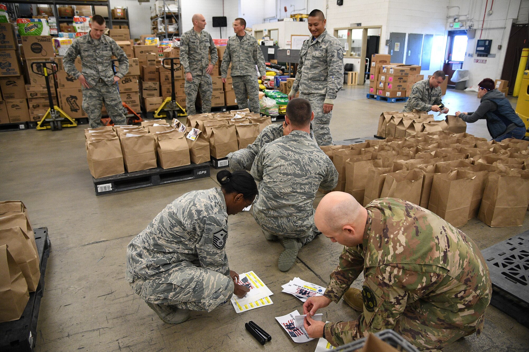 Members of Hill's First Sergeant Council pack Operation Warm Heart Thanksgiving bags on Nov. 2, 2018, at Hill Air Force Base, Utah. The bags of sides dishes along with a turkey and a pie donated by commissary vendors will be delivered to selected Airmen to assist with the upcoming holiday. (U.S. Air Force photo by R. Nial Bradshaw)
