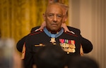 President Donald J. Trump places the Medal of Honor around retired Marine Corps Sgt. Maj. John L. Canley's neck at the White House in Washington D.C., Oct. 17, 2018. DLA Troop Support Clothing and Textiles’ customer, supplier and technical quality teams worked together to ensure Canley received a custom Marine Corps dress coat in time for the ceremony.