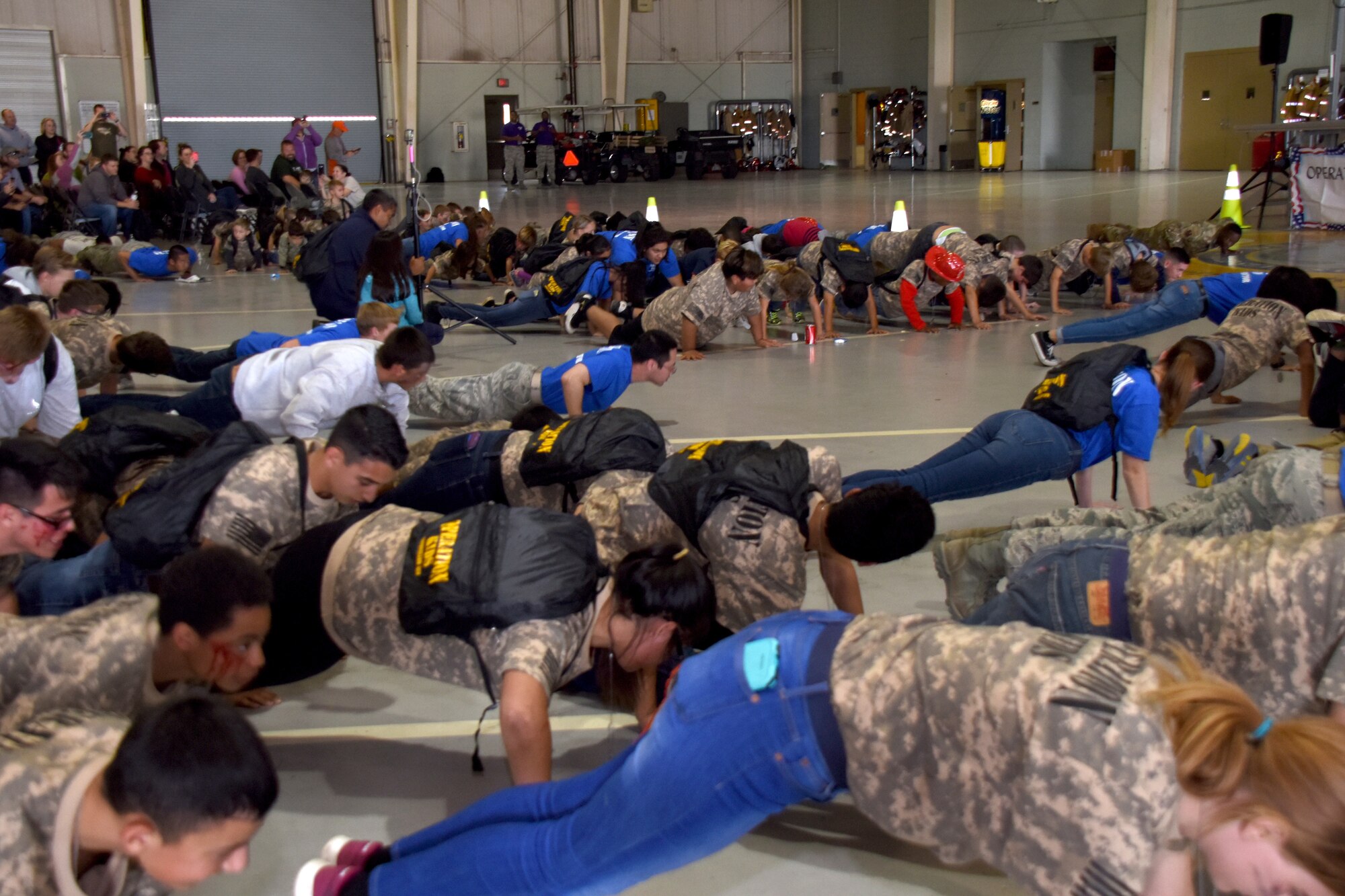 Participants in Operation KIDS perform pushups before receiving their completion certificates at the Louis F. Garland Department of Defense Fire Academy on Goodfellow Air Force Base, Texas, Nov. 3, 2018. After completing the pushups the attendees went with their drill instructors to receive their certificates from Col. Ricky Mills, 17th Training Wing commander. (U.S. Air Force photo by Airman 1st Class Seraiah Hines/Released)