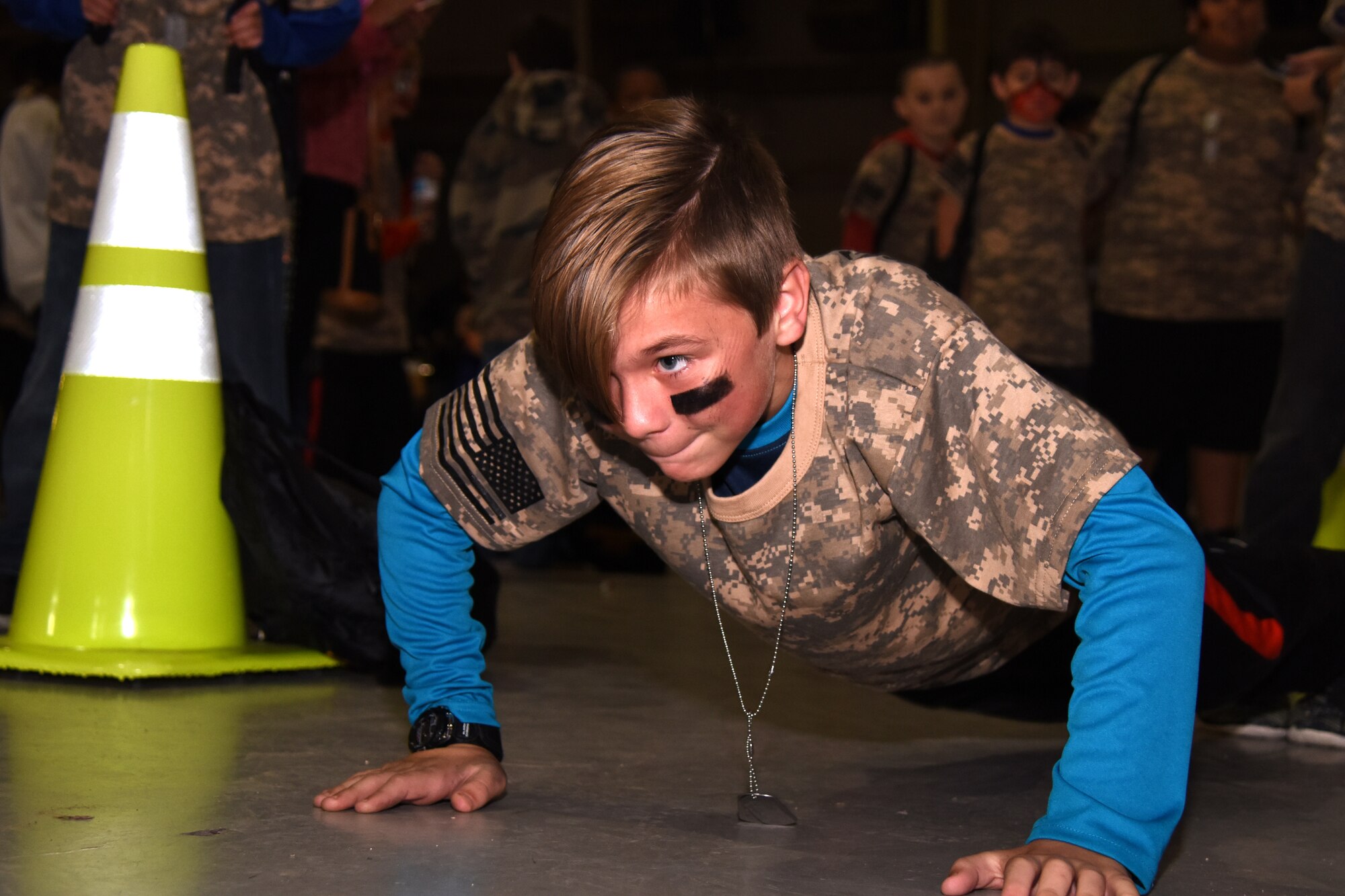Scott, an Operation KIDS participant competes in a push-up competition while waiting for the processing of the rest of his group at the Louis F. Garland Department of Defense Fire Academy Goodfellow Air Force Base, Texas, Nov. 3, 2018. Drill instructors showed groups different parts of being in the military, including pushups, proper formation techniques and facing movements. (U.S. Air Force photo by Airman 1st Class Seraiah Hines/Released)