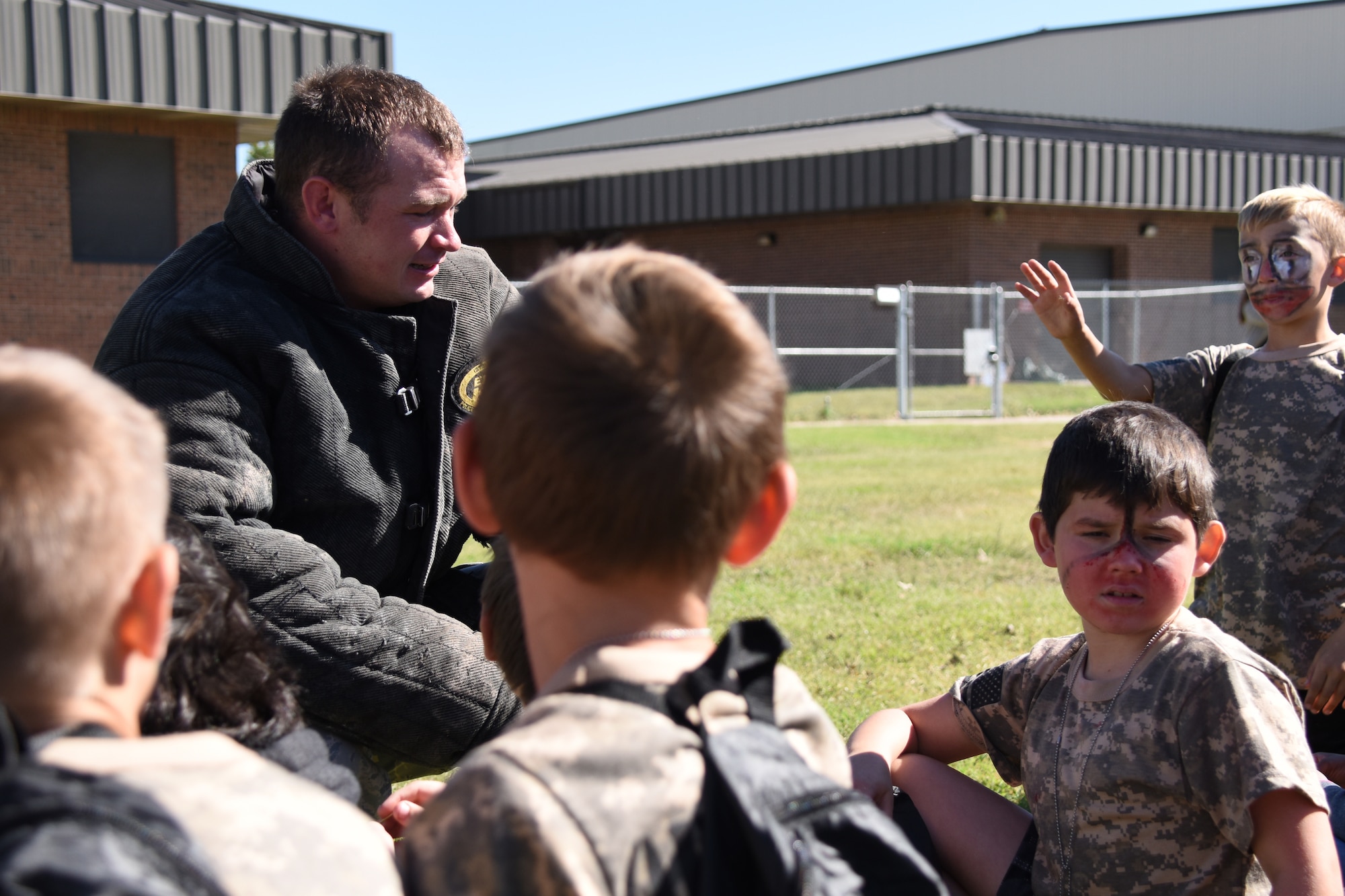 U.S. Staff Sgt. Dakoda Riddle, 17th Security Forces Squadron military working dog trainer, answers questions after a demonstration for Operation KIDS at the Louis F. Garland Department of Defense Fire Academy on Goodfellow Air Force Base, Texas, Nov. 3, 2018. The kids got to see Hugo, a military working dog, and Senior Airman Shane Myers, 17th SFS military working dog handler, perform a variety of procedures for searching and detaining suspicious individuals. (U.S. Air Force photo by Airman 1st Class Seraiah Hines/Released)