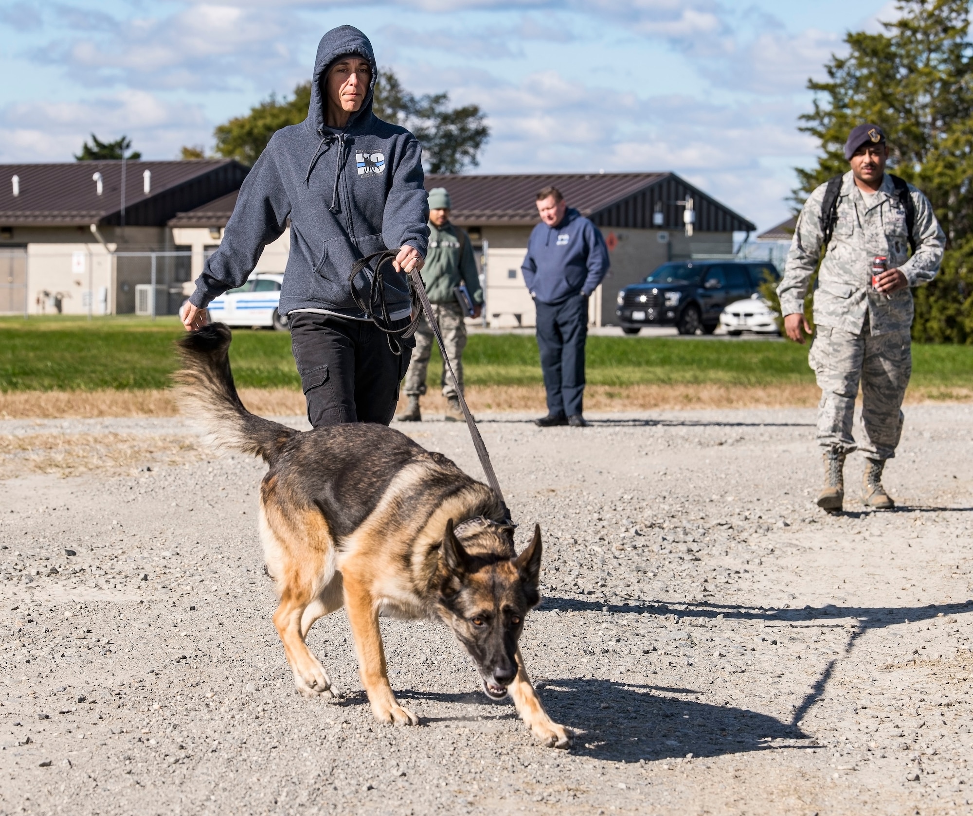 Sgt. Katie Edgar, Worcester County, Md., Sheriff’s Department K-9 Unit supervisor, along with her partner, “Brina,” a three-year-old German Shepherd narcotics detection dog, search for hidden narcotics Oct. 24, 2018, at Dover Air Force Base, Del. Tech. Sgt. Dominique Singleton, right, 436th Security Forces Squadron military working dog kennel master, set up two separate areas containing narcotics or explosives. (U.S. Air Force photo by Roland Balik)