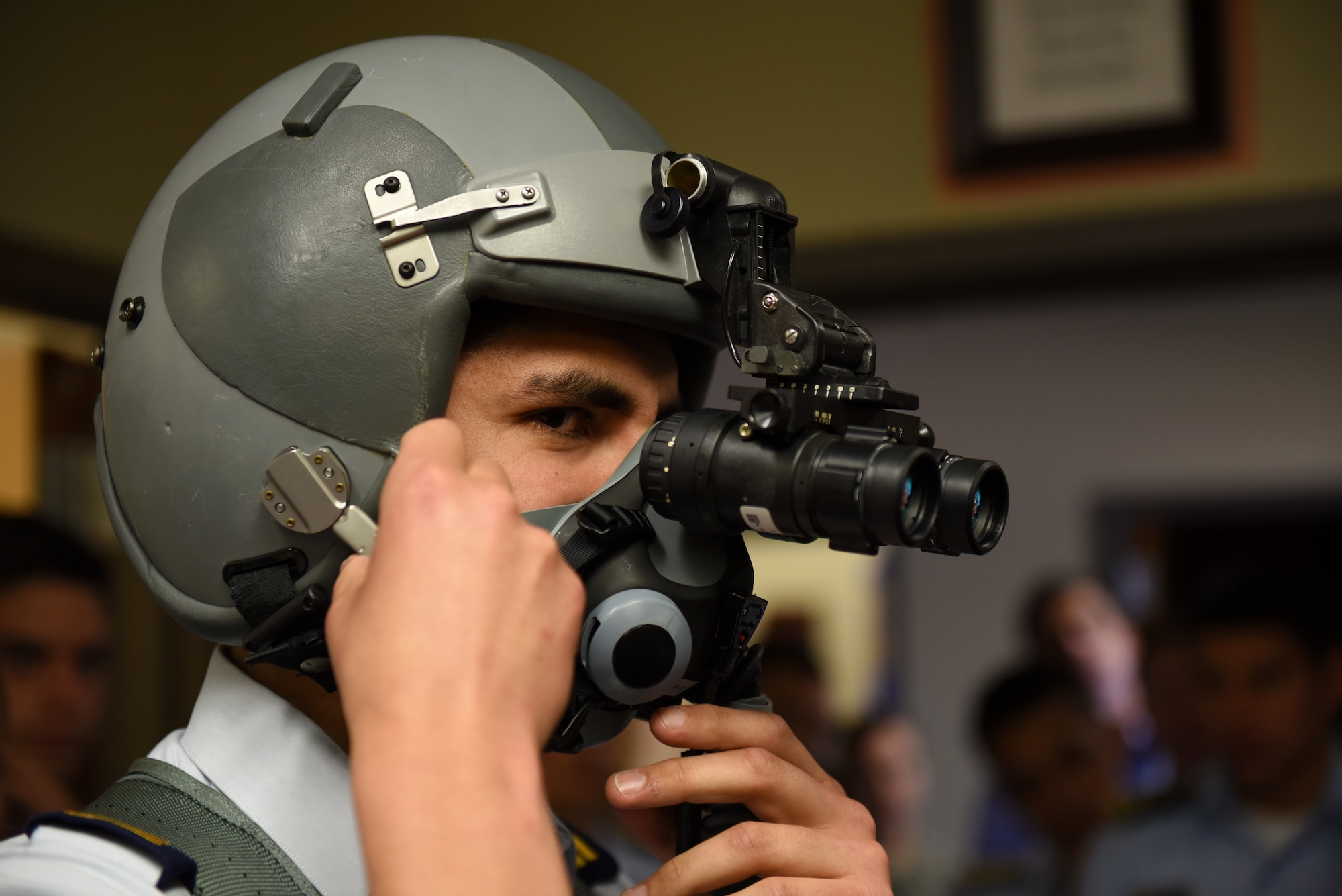 A cadet from a Latin American air service academy tries on an F-16 fighter pilot’s helmet with night vision goggles Oct. 31, 2018, at Luke Air Force Base, Ariz. Cadets from air service academies across South America visited Luke as part of the Department of Defense Latin American Cadet Initiative. (U.S. Air Force photo by Senior Airman Ridge Shan)
