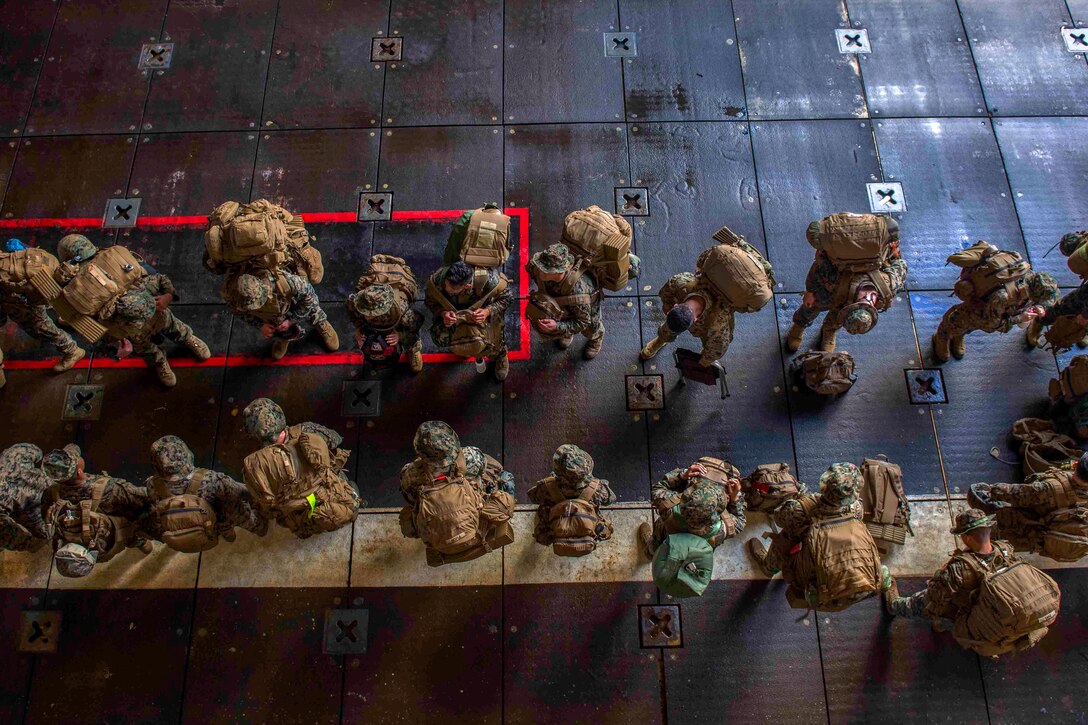 Marines assemble in the well deck of the USS Ashland to debark for typhoon aide efforts.