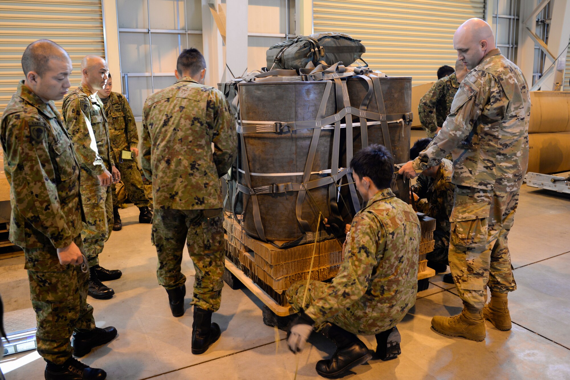 Japan Ground Self-Defense Force soldiers assigned to the 1st Airborne Brigade and members of the 374th Logistics Readiness Squadron, Combat Mobility Flight secure bundles at Yokota Air Base, Japan, Nov. 2, 2018, during Keen Sword 19.