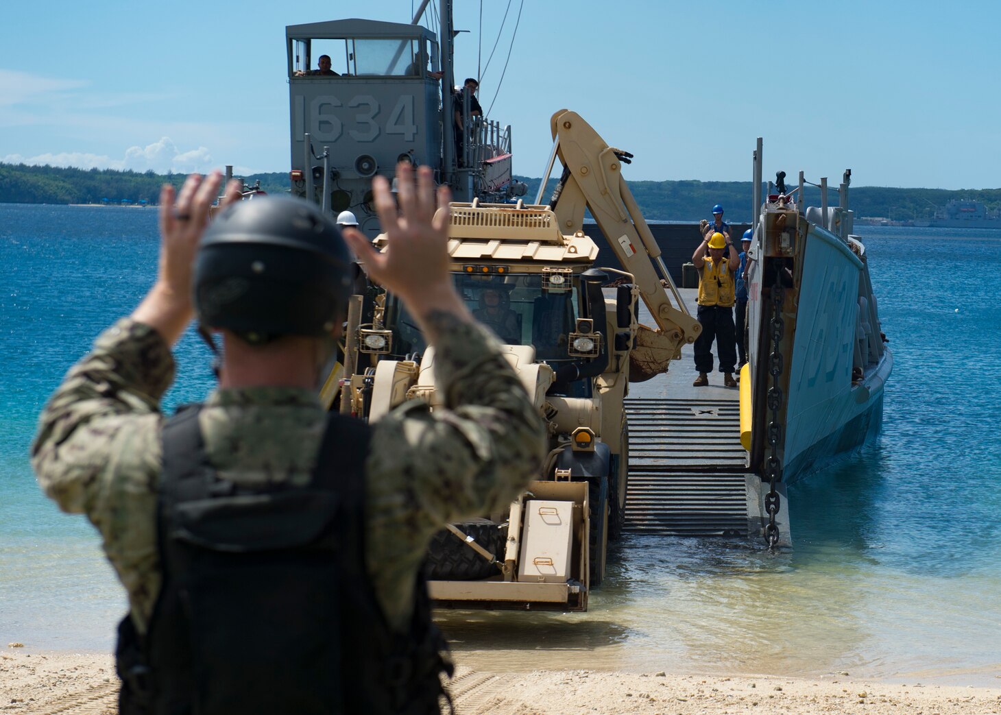 SANTA RITA, Guam (Nov. 06, 2018) Sailors assigned to Landing Craft Utility (LCU) 1634, attached to Naval Beach Unit (NBU) 7 forward-deployed to Sasebo, Japan, embarked aboard amphibious dock landing ship USS Ashland (LSD 48), direct a Solider assigned to the Guam Army National Guard as she drives to pick up supplies for Super Typhoon Yutu recovery effort. Service Members from Joint Region Marianas and U.S. Indo-Pacific Commands are providing Department of Defense support to the Commonwealth of the Northern Mariana Islands civil and local officials as part of the FEMA-supported Super Typhoon Yutu recovery effort.