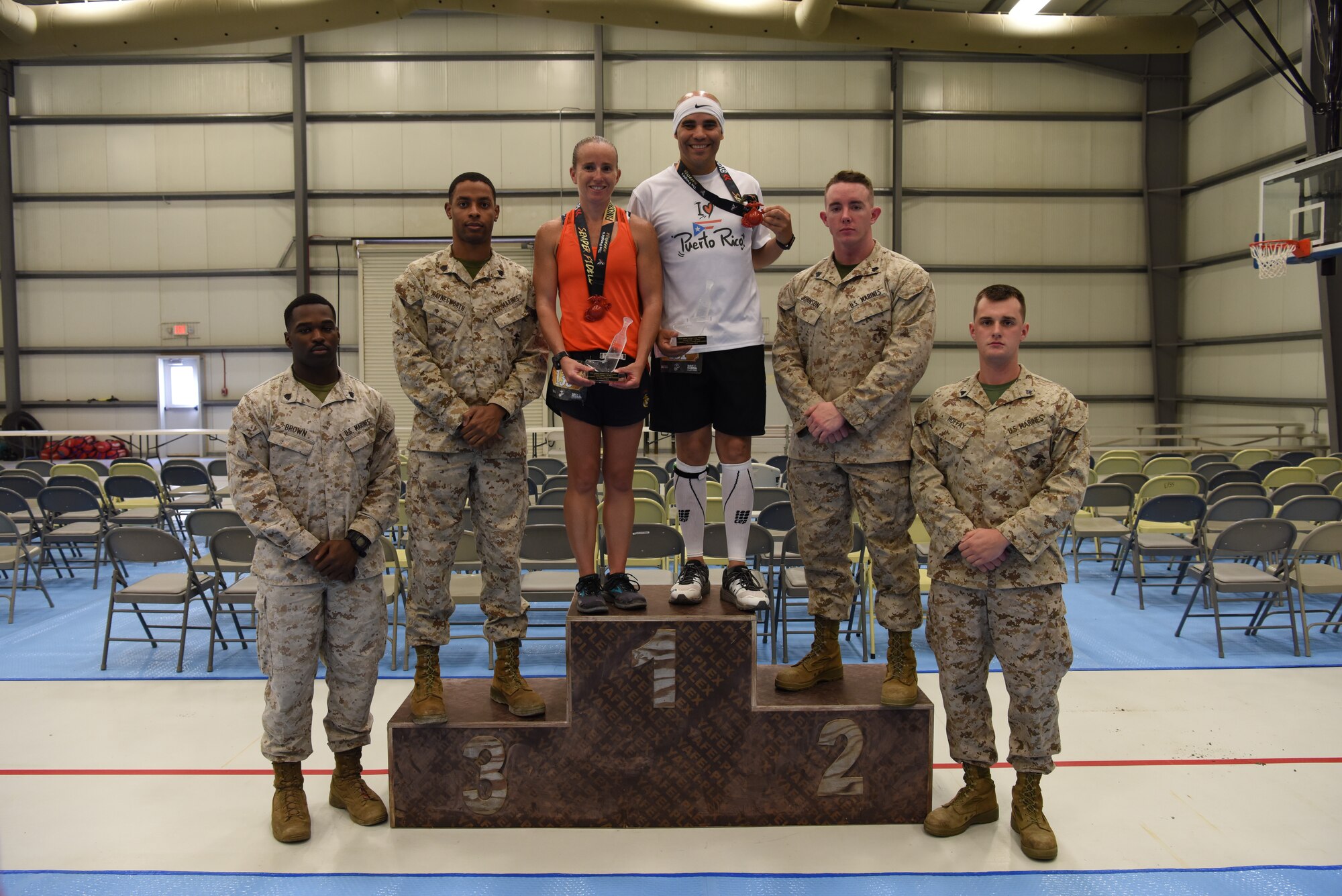 Marines presented medals to the first place female and male runners U.S. Marine Corps Capt. Heather Judy, 727nd Expeditionary Air Control Squadron and U.S. Air Force Lt. Col. Alfredo Laboy, 380th Expeditionary Medical Group deputy commander, after the Marine Corps Marathon at Al Dhafra Air Base, United Arab Emirates, Oct. 27, 2018.