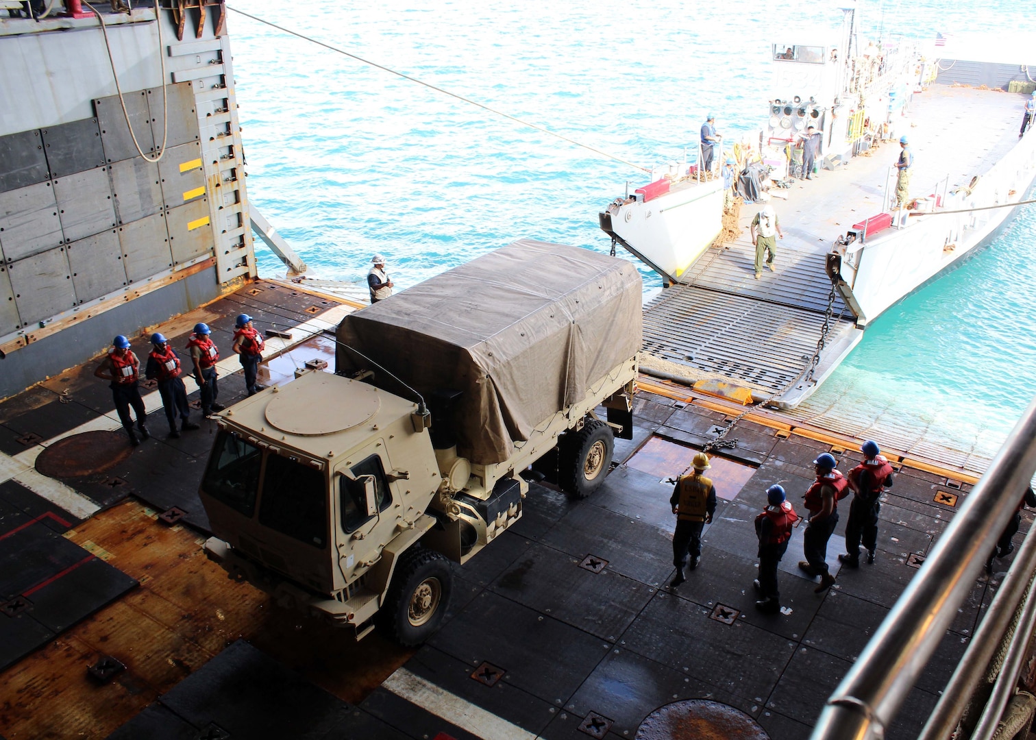 Heavy equipment vehicles from the 1224th Engineering Support Company, Guam Army National Guard, are loaded onto the well-deck of the Whidbey-Island class amphibious dock landing ship USS Ashland (LSD 48) via Navy Landing Craft, Utility (LCU) 1634, attached to Naval Beach Unit (NBU) 7 on Naval Base Guam.