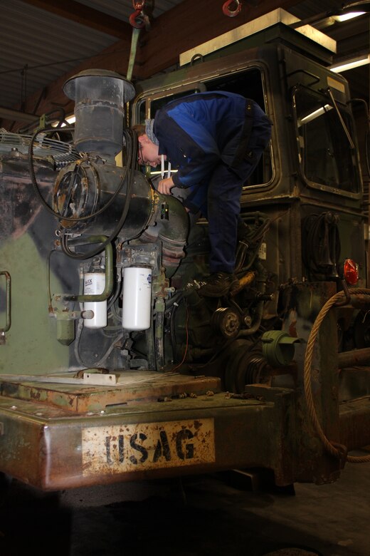 Robin Siller, mechatronic apprentice BASOPS Maintenance Division in his third year , performs repairs on a  garrison scraper at the Maintenance Activity Vilseck building, Vilseck Oct. 29. After three and a half years of training in the division’s automotive section apprentices have to pass two exams to become a certified mechanic, with the option to earn further certifications as a Service Technician, Meister, or Techniker. Since 1998, BASOPS Maintenance, a directorate of the 405th AFSB, certifies and trains youth in a variety of directorate related fields, ranging from electronics repairman to contracting officer representative, supply specialist to administrative assistance