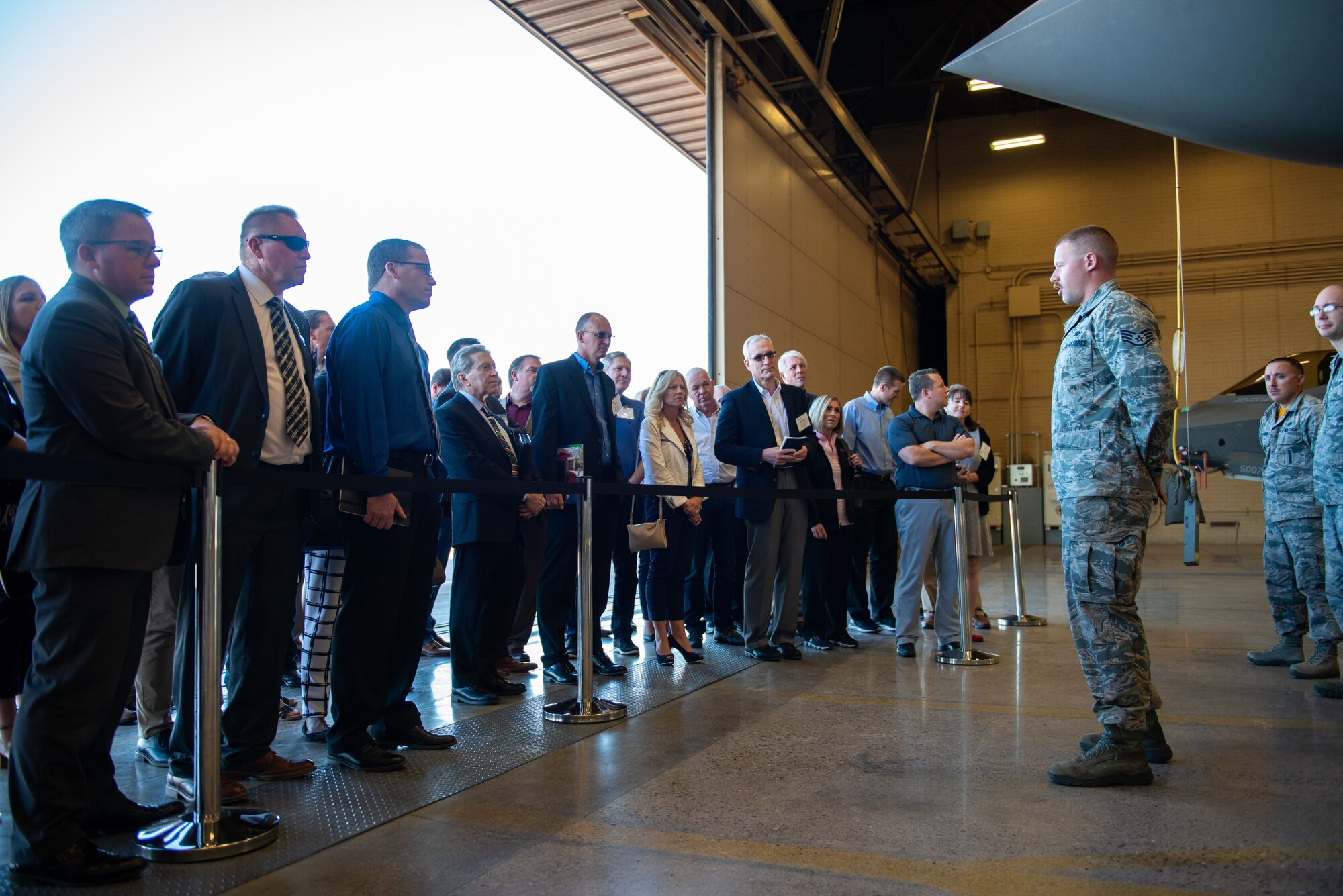 An Airman assigned to the 61st Aircraft Maintenance Unit speaks to members of the Personalized Learning Cohort during a tour at Luke Air Force Base, Ariz., Nov. 2, 2018. Cohort members toured the base to gain insight on the 56th Fighter Wing’s pilot training mission. (U.S. Air Force photo by Senior Airman Alexander Cook)