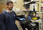Joseph Spano, Naval Medical Research Unit San Antonio Craniofacial Health and Restorative Medicine Directorate research engineer, works on a portable Raman spectrometer that is being utilized for a research project at NAMRU-SA focused on the development of diagnostic platforms that can better identify bacterial pathogens in wounded service members. The portable spectrometer is a user-friendly, ruggedized device that is field-deployable and capable of obtaining surface-enhanced Raman scattering, or SERS, spectra which are characteristic to individual bacterial strains. The portable Raman offers superior performance to handheld spectrometers as well as increased spatial resolution when coupled to a microscope.  The device is being used for method and platform development as well as to characterize bacteria, build representative spectral libraries and assess classification capabilities.