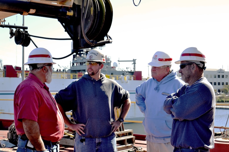 photo of members of the U.S. Army Corps of Engineers take part in an on-camera interview on the deck of the derrick boat Elizabeth