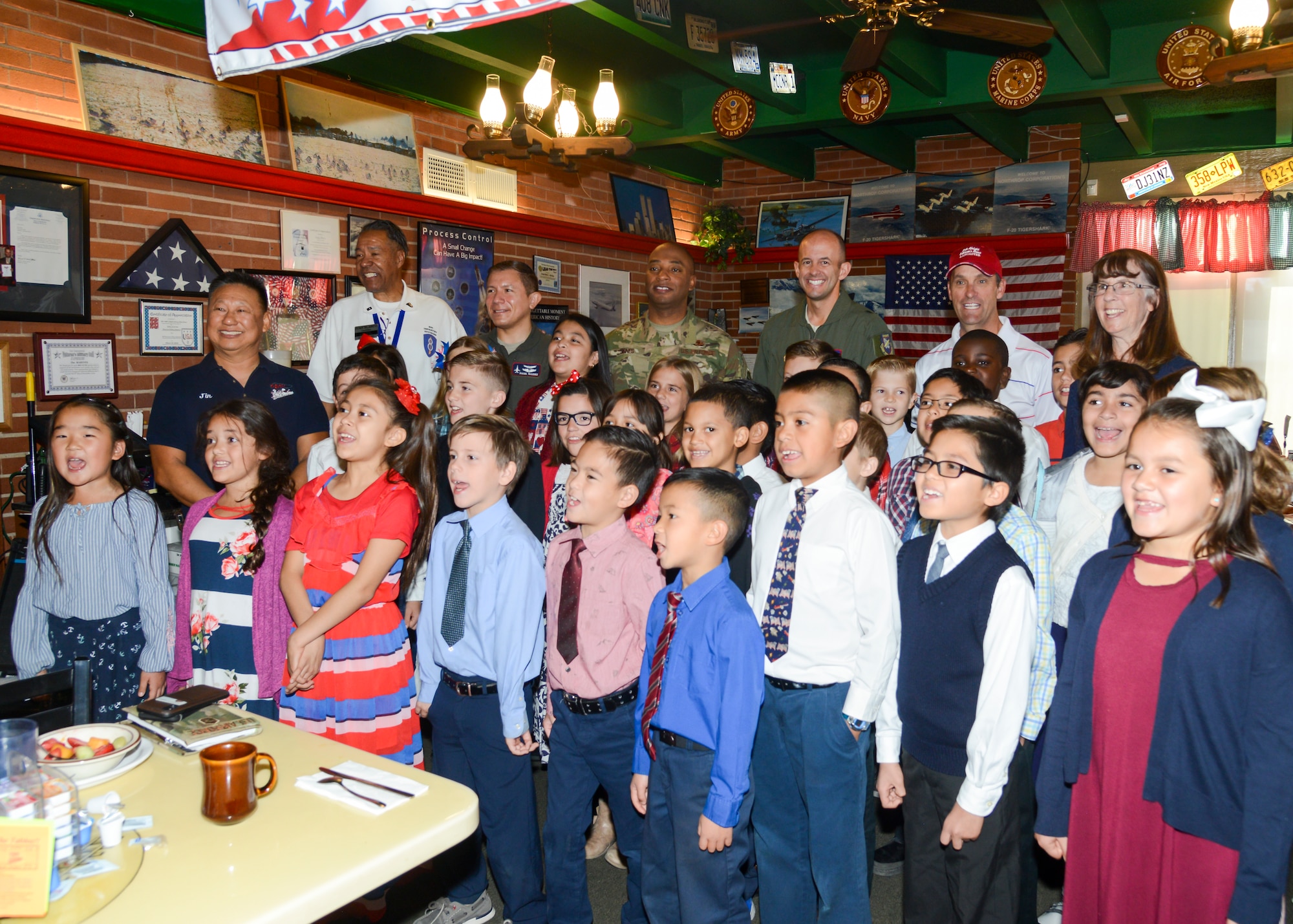 Brig. Gen. E. John Teichert and Command Chief Master Sgt. Roosevelt Jones, 412th Test Wing commander and command chief master sergeant, pose for a photo with children from Lancaster Baptist School and U.S. Rep. Steve Knight photo during a Coffee4Vets gathering at Crazy Otto’s Diner in Lancaster, California, Nov. 6. Coffee4Vets meet every Tuesday at the restaurant for fellowship and camaraderie. (U.S. Air Force photo by Giancarlo Casem)