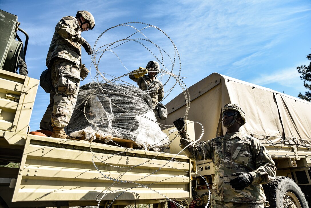 U.S. Army Soldiers assigned to the 331st Transportation Company, 11th Trans. Battalion, 7th Trans. Brigade (Expeditionary), unload C-Wire from the trailer of a Light Medium Tactical Vehicle at Fort Pickett, Virginia, Oct. 23, 2018.