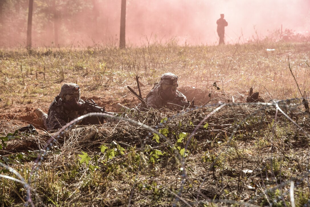 U.S. Army Soldiers assigned to the 331st Transportation Company, 11th Trans, Battalion, 7th Trans. Brigade (Expeditionary), take cover during a gas attack during Area Defense training at Fort Pickett, Virginia, Oct. 29, 2018.