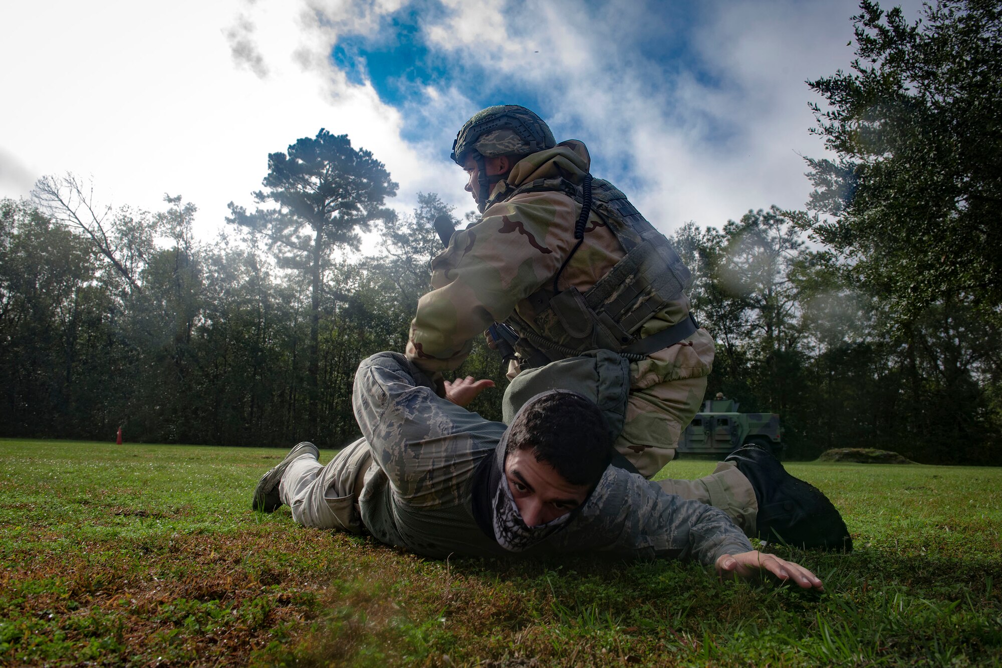 A defender from the 23d Security Forces Squadron detains a mock insurgent during exercise Flying Tigers 19-01C, Nov. 6, 2018, at Moody Air Force Base, Ga.  The weeklong event is the second phase of a contingency operation exercise which tests Moody Airmen on their ability to successfully survive in a contested and degraded operational environment while donning mission-oriented protective posture (MOPP) gear. (U.S. Air Force photo by Senior Airman Greg Nash)