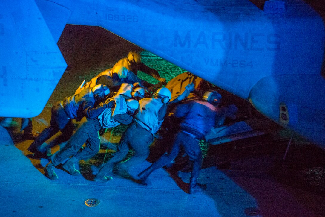 Marines load equipment onto an MV-22 Osprey.