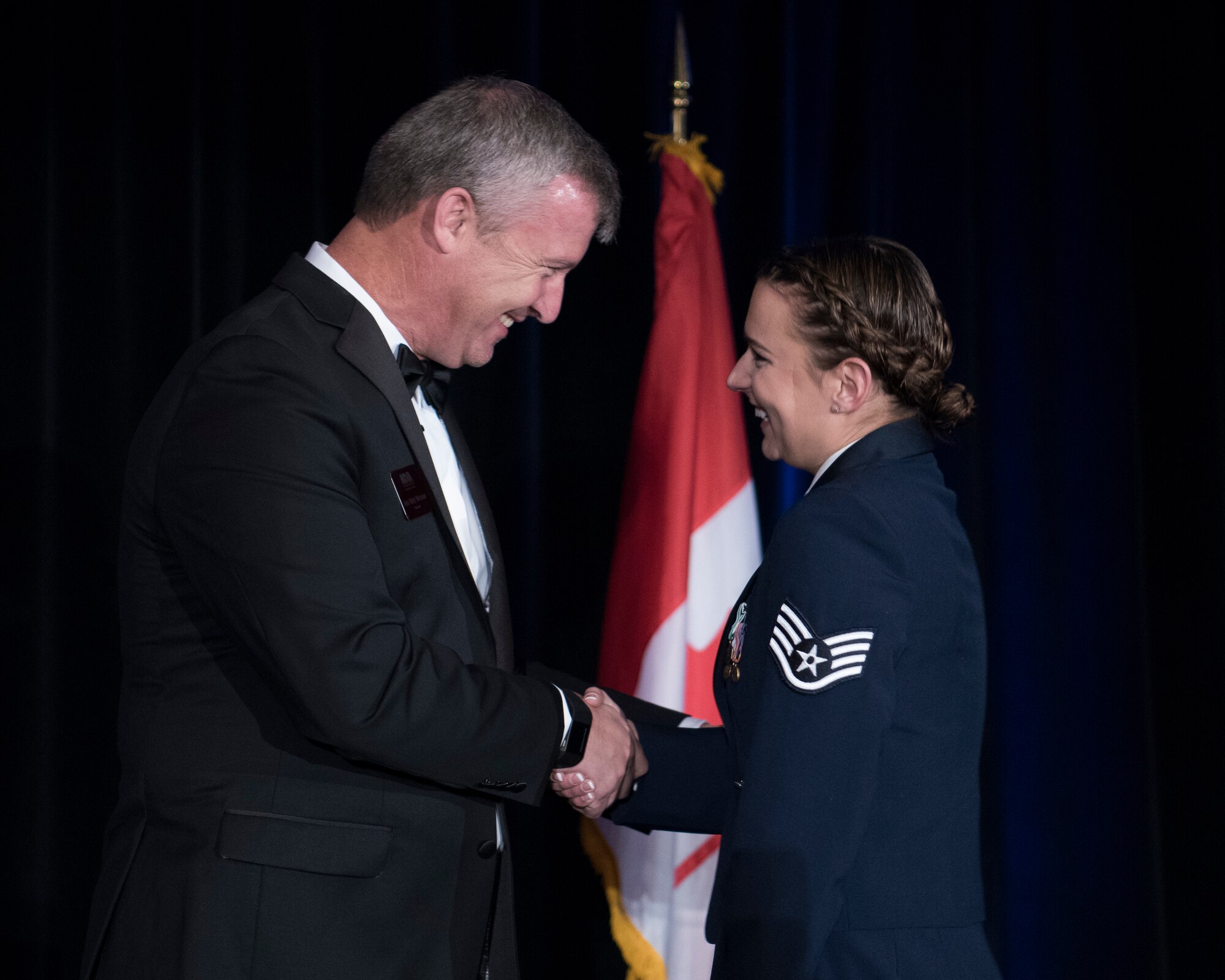 Kevin Mortenson, President of the Rocky Mountain Chapter of the National Defense Industrial Association (left), presents the Patriot Award to Staff Sgt. Megan Richards of Headquarters, Air Force Space Command (right) in Colorado Springs, Colorado, Nov. 2, 2018. The Patriot Award recognizes outstanding service members from all branches of the military serving in the Colorado Springs area. Richards was selected for her achievements as non-commissioned officer in charge of Special Programs Administration for the AFSPC Directorate of Plans, Programs and Financial Management and her community service with Veterans Stand Down and Care and Share Food Pantry. (U.S. Air Force photo by Dave Grim)